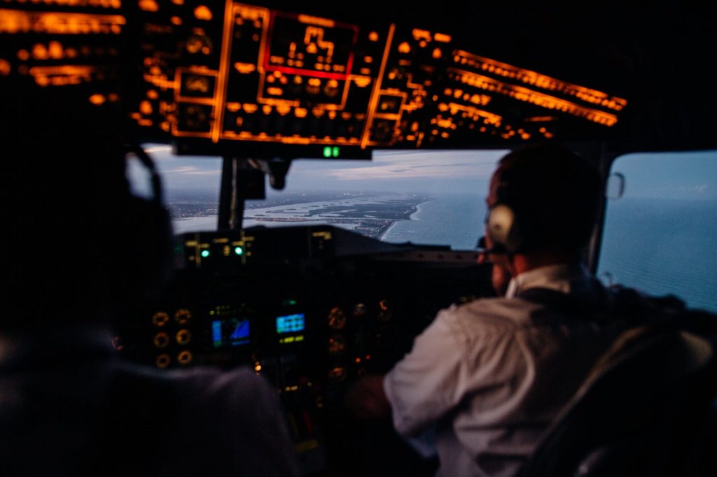 anonymous pilots in aircraft cockpit flying over sea