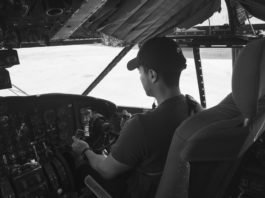 grayscale photo of man flying a plane