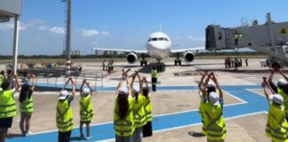 Aena Brasil coloca crianças para se sentirem balizando um avião no pátio do aeroporto